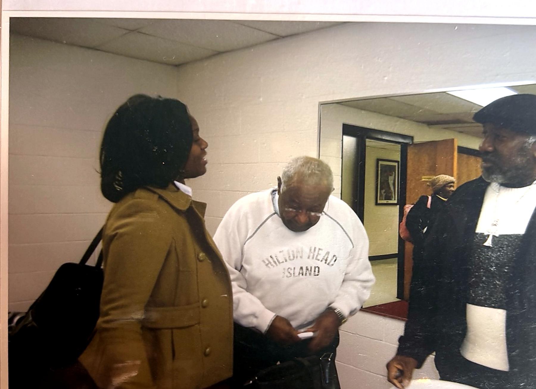 Community members talking in a hallway before a healthcare meeting.