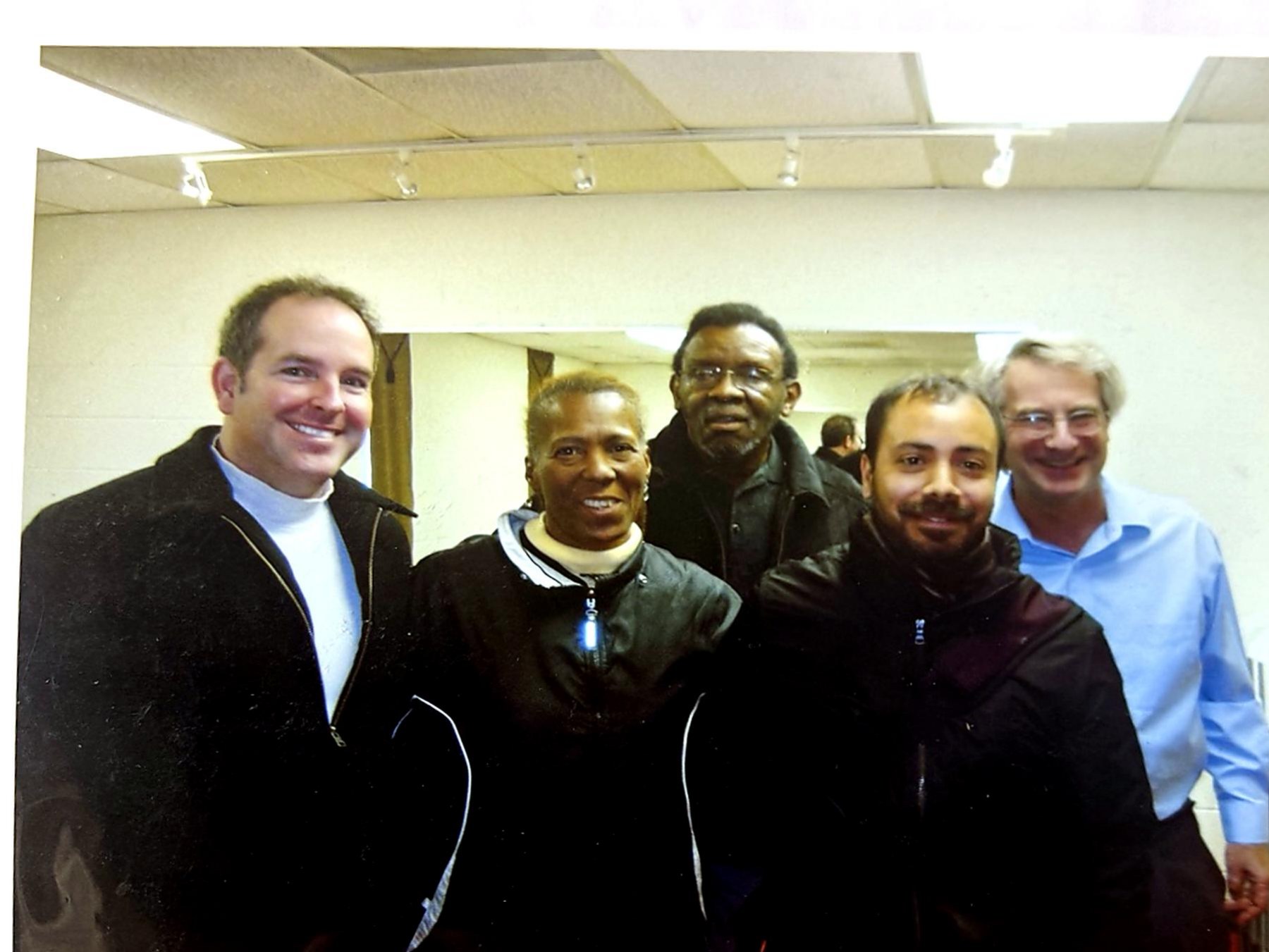 Five coalition partners standing together for a group portrait indoors.