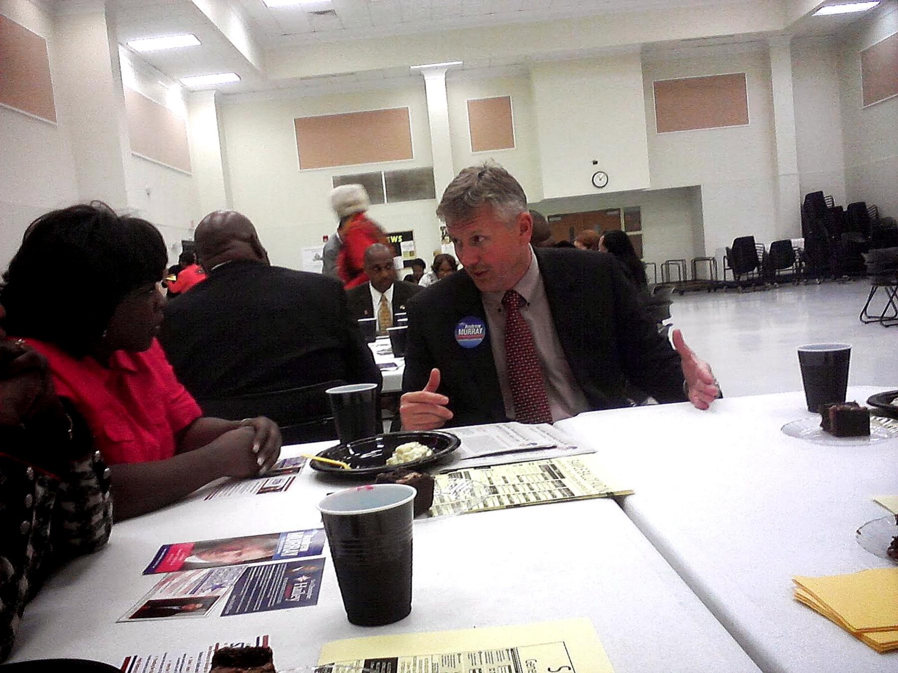 Community members meeting with an official across a table in a community room.