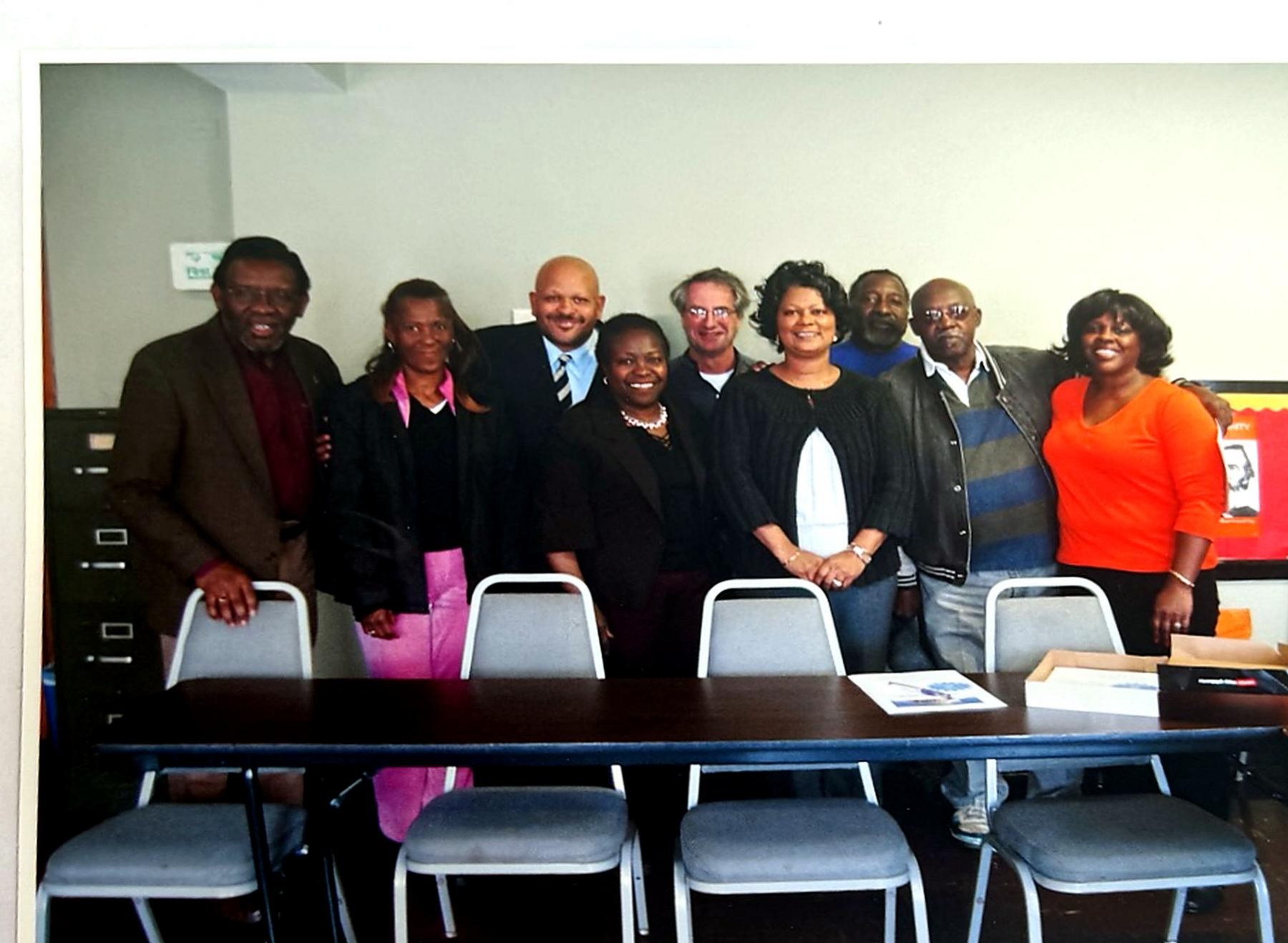 A group of coalition members standing behind a conference table for a group photograph.