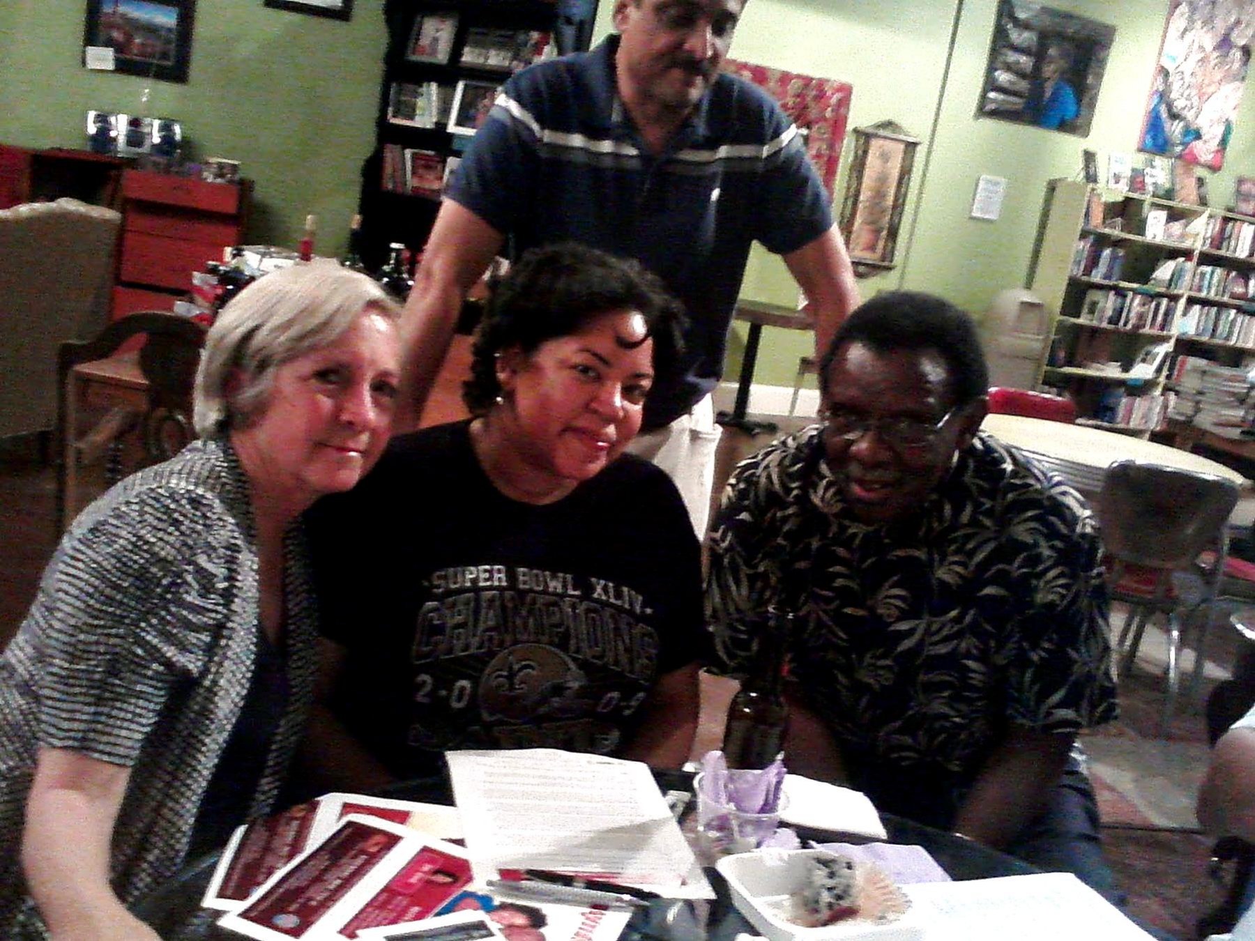 Community volunteers seated around a table with papers and materials during a planning meeting.