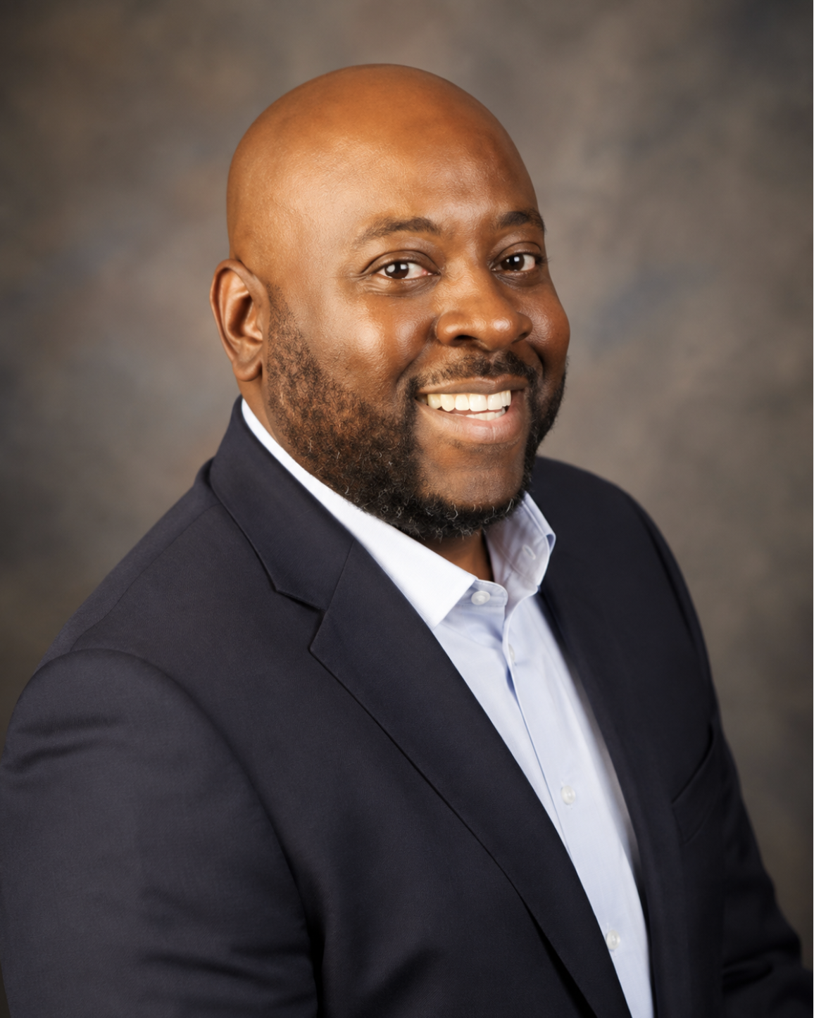 Portrait of CHCC Faith Leader Pastor Sidney Phillips wearing a dark suit and light blue shirt.